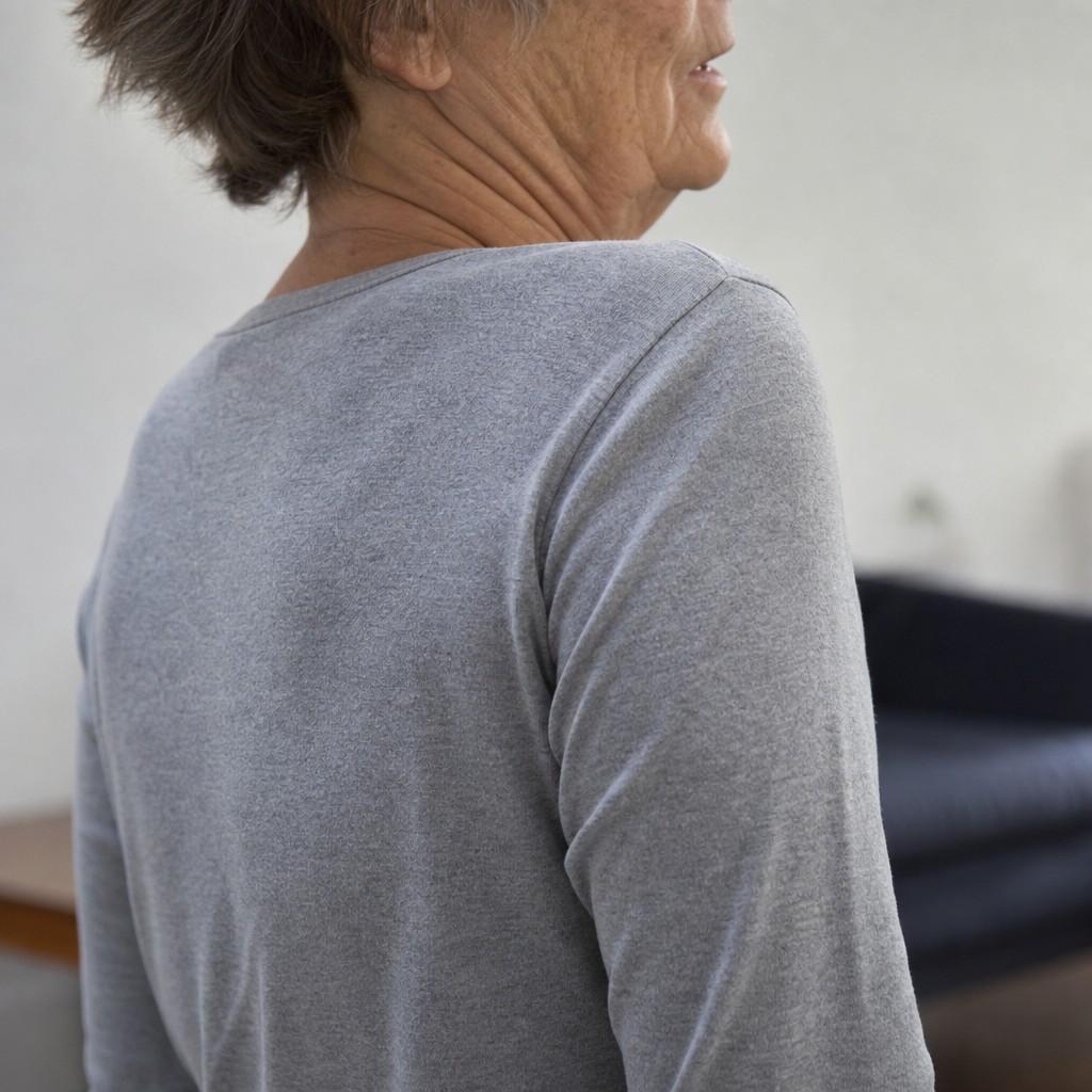 Close-up of an older person rolling their shoulders during gentle mobility work